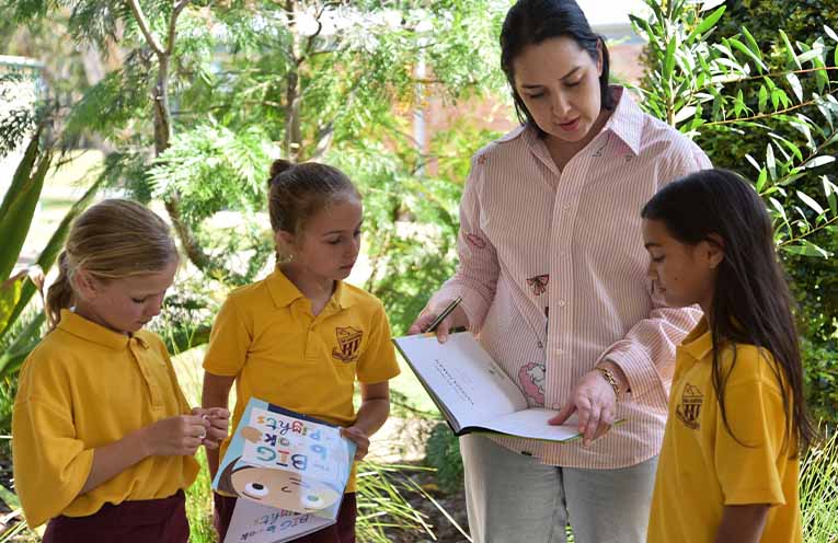 Zoe Robinson reads the new books with Tea Gardens Public School students.