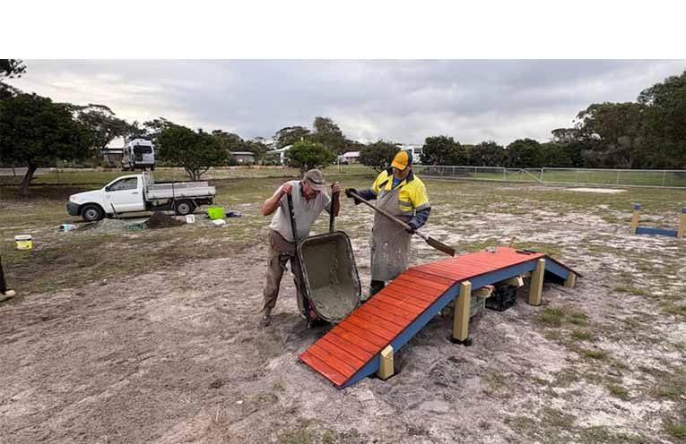Lions Rob and Thomas pour concrete to solidify the foundations of the dog park’s new equipment. Photo: TG Lions
