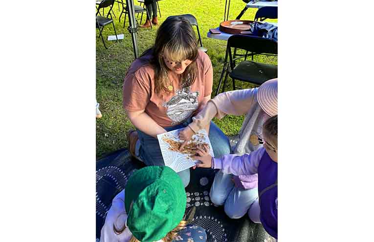 Estelle Leishman demonstrating how to use ochre as paint. Photo: Rachel Barry.