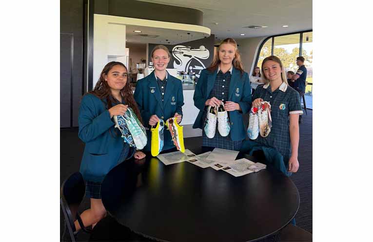 Students from Catherine McAuley Catholic College, Medowie present Newcastle Knights players with their hand-painted boots honouring Indigenous Round. Photos: CMCC Facebook.