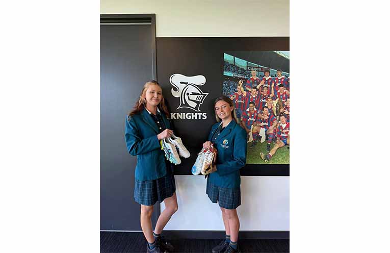 Students from Catherine McAuley Catholic College, Medowie present Newcastle Knights players with their hand-painted boots honouring Indigenous Round. Photos: CMCC Facebook.