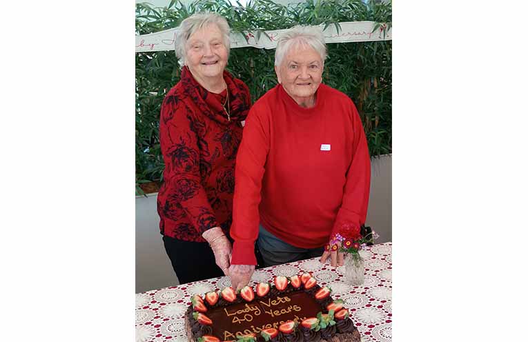 Betty Clinch and Jan Bardier cut the anniversary cake.