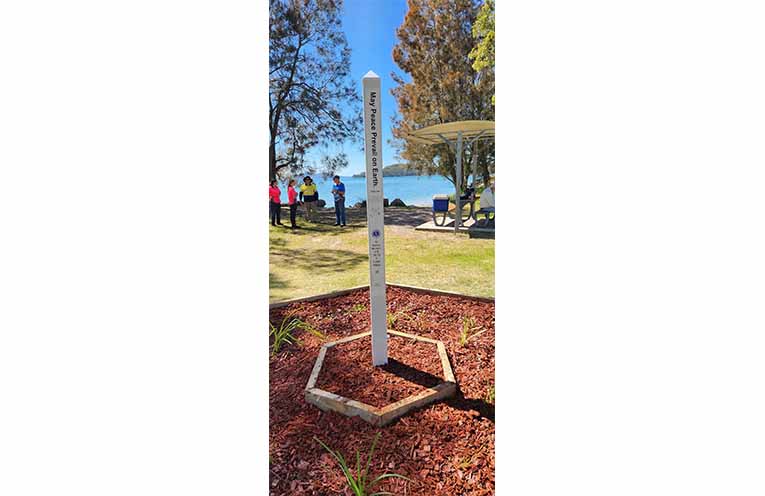 The Peace Pole stands proudly at Tilligerry’s foreshore, with its message ‘May Peace Prevail on Earth’ symbolising unity. Photo: Supplied.